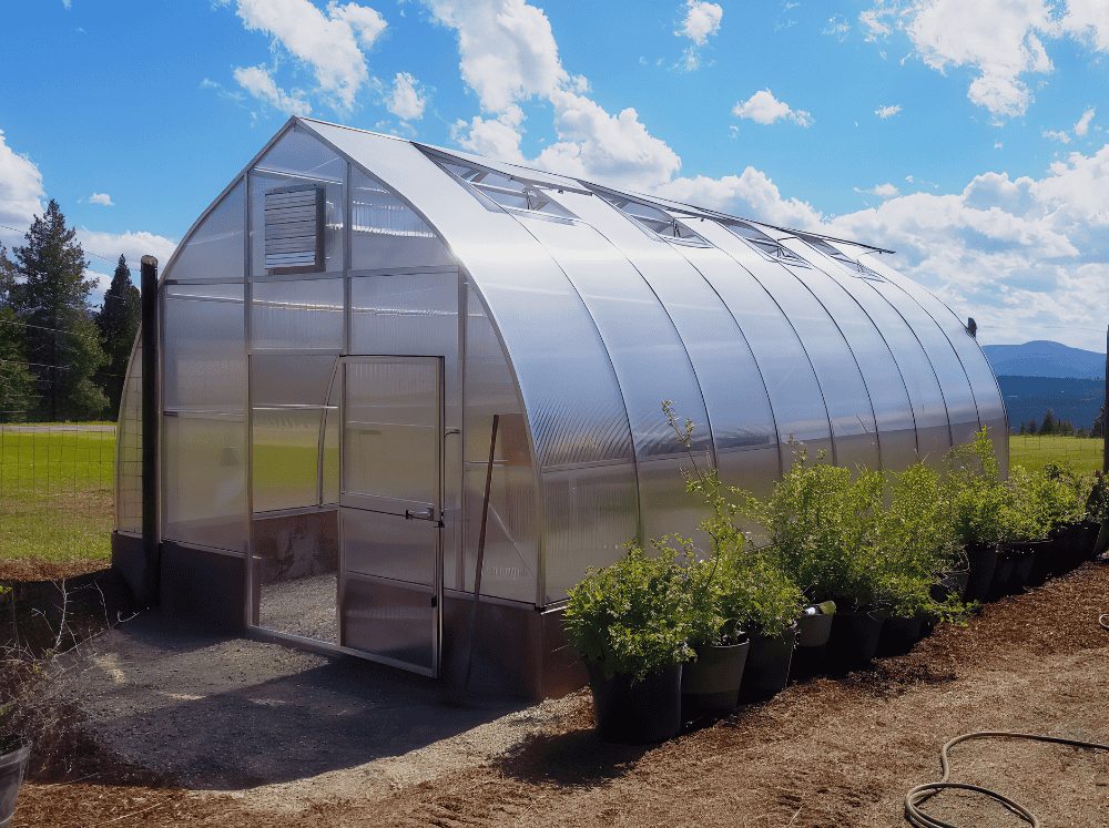 Very large Riga polycarbonate gothic arch greenhouse set in an open field as the best greenhouse kit for wind and snow