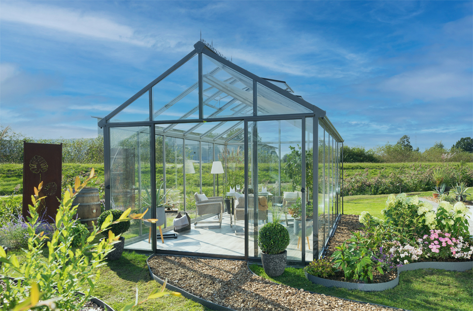 Glass greenhouse exterior view with lounge area inside