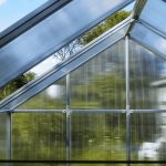 Close up of the interior of an empty polycarbonate greenhouse displaying polycarbonate panes with the Greenhouse Emporium logo at the top.