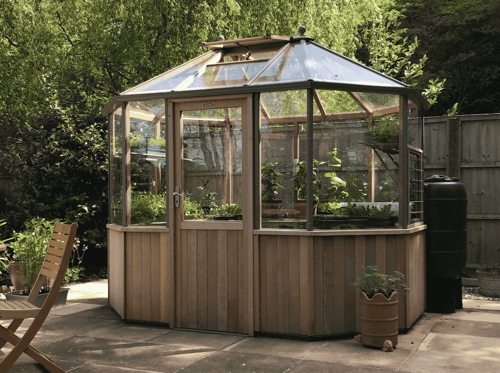 Exterior of an Octagonal greenhouse with a wooden stem wall and frame