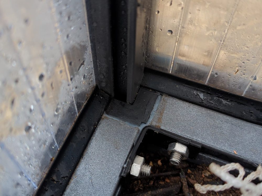 Close up of caulking in a greenhouse showing proper sealing.