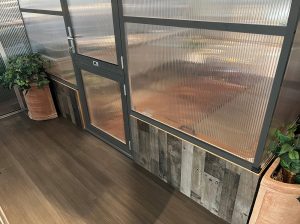 Lower part of the Nelke Pro Drop Door Kit showing how the Nelke Pro Greenhouse sits on a stem wall